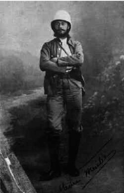 A studio portrait of a young Frenchman in a pith helmet