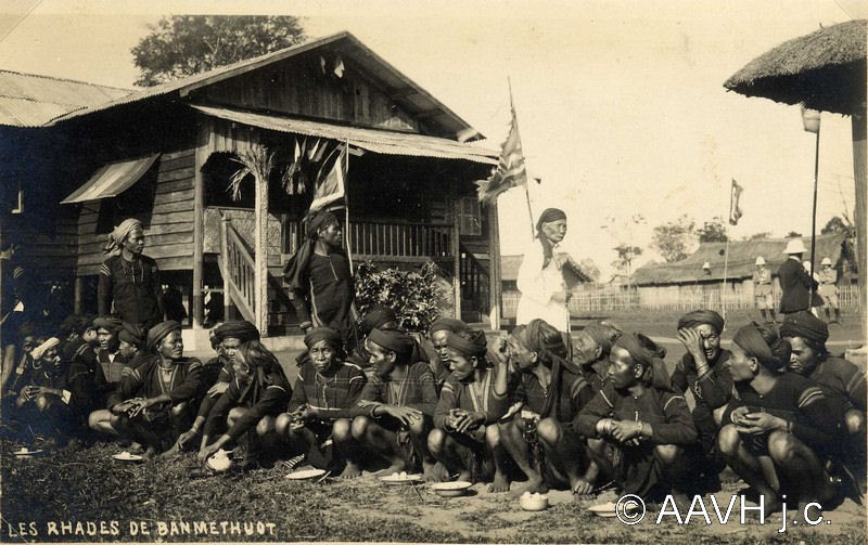 A group of Rhade men in dark shirts standing in rows for a photograph