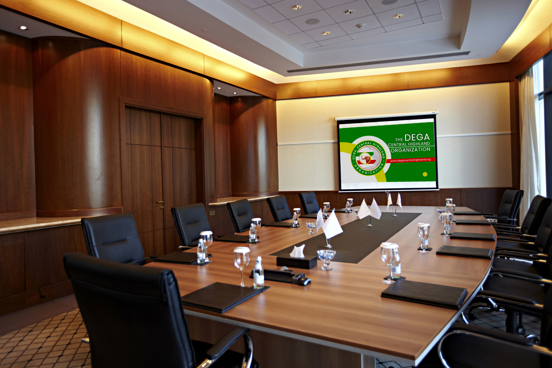 An empty conference room with a long table and a screen showing the DCHO emblem
