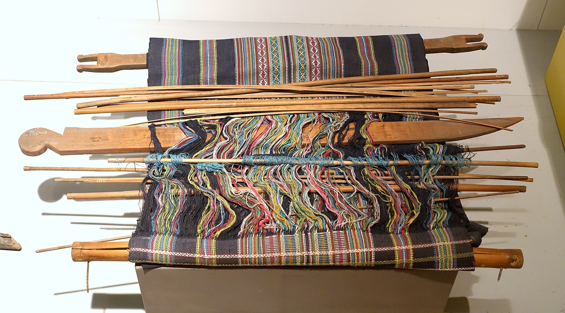 A backstrap loom with a length of patterned cloth