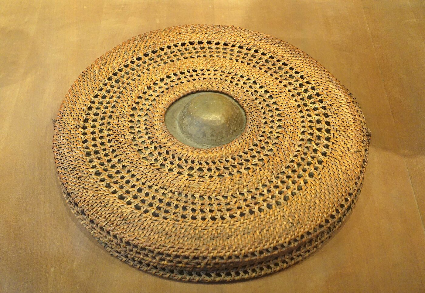A bronze gong in a woven rattan carrying case